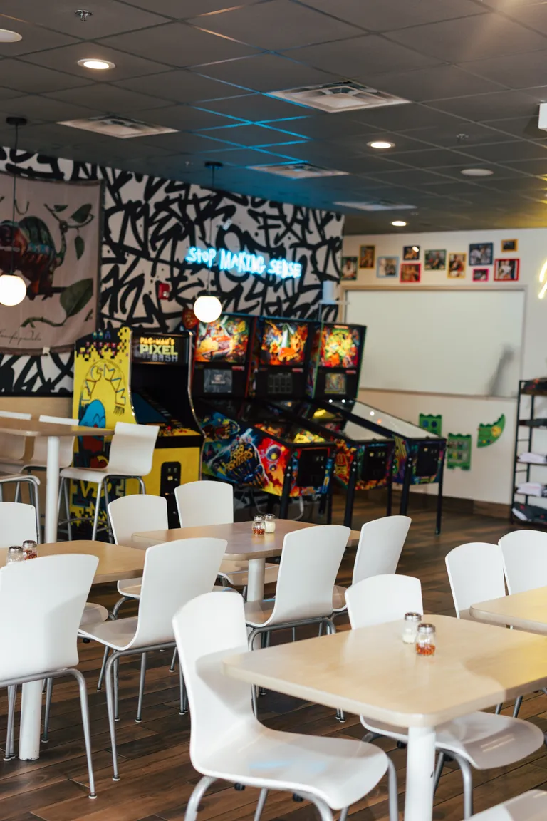 The Uncle G's dining room, with arcade cabinet and pinball machines under the graffiti mural