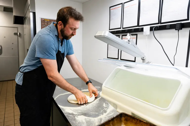 Shaping dough balls at the prep bench