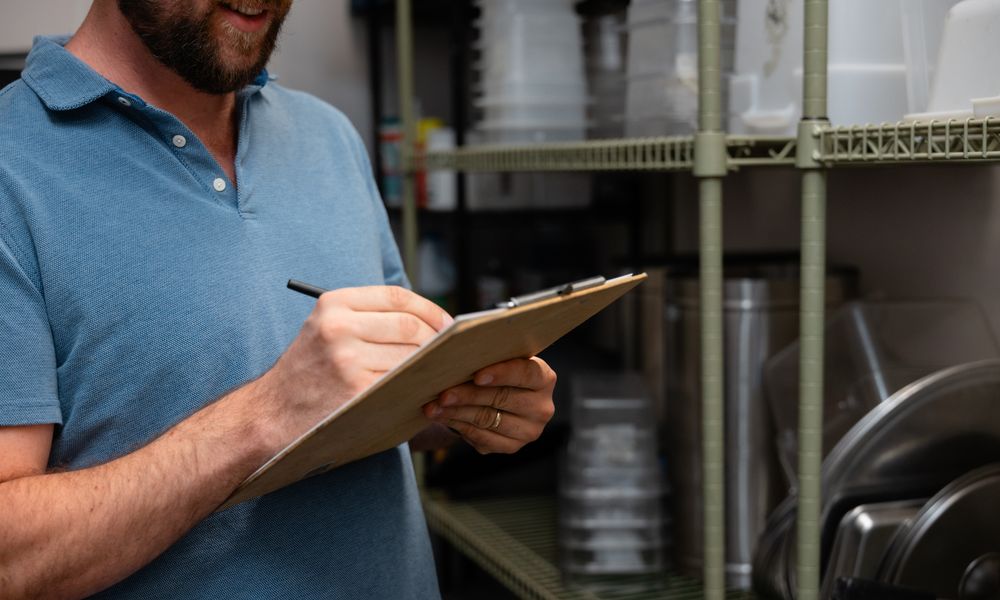 Taking inventory notes on a clipboard in a dry storage room