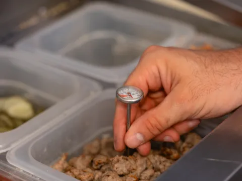 Checking temperatures on a prep line with a probe thermometer