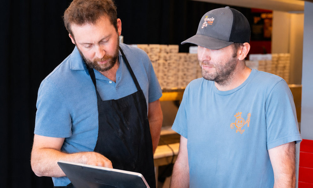 George pointing at a Toast POS screen while walking a teammate through it