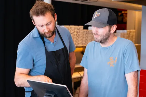George pointing at a Toast POS screen while walking a teammate through it